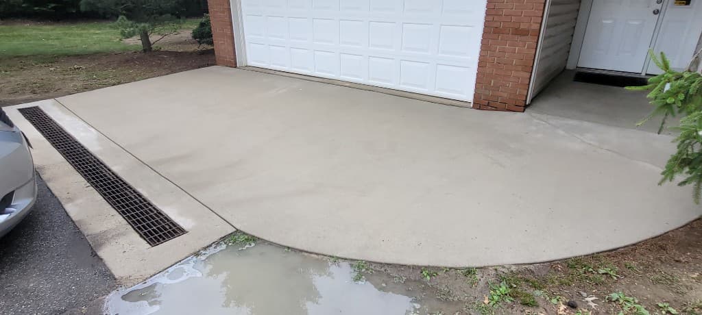Bright clean concrete driveway and garage apron after professional pressure washing
