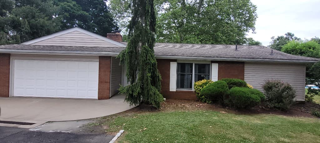 Clean ranch-style home exterior with a freshly washed concrete driveway